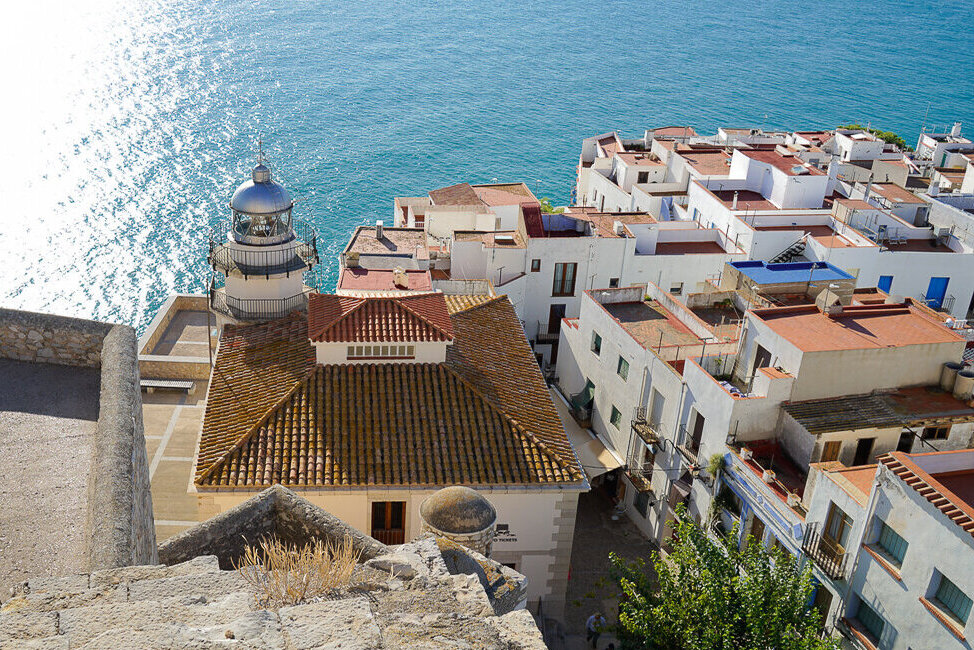 View of the lighthouse, white buildings with red roofs and sea views in Peniscola, Spain