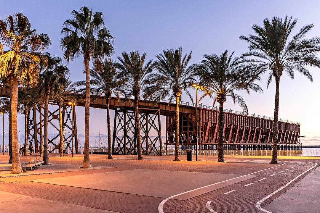 Iron pier with palm trees in front of it