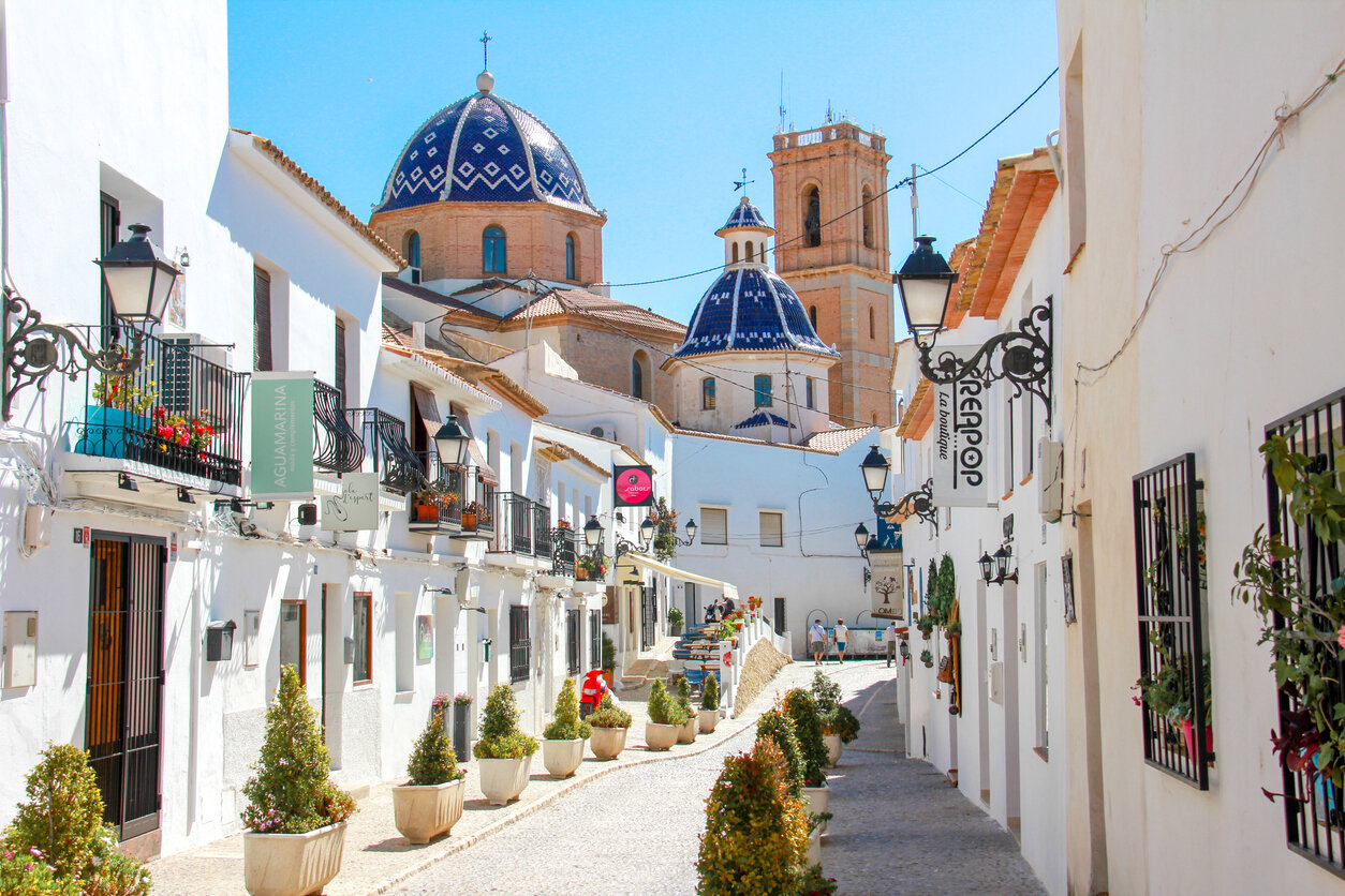 Narrow whitewashed street in the old town of Altea with the Cathedral in the background. Valencian Community, Spain