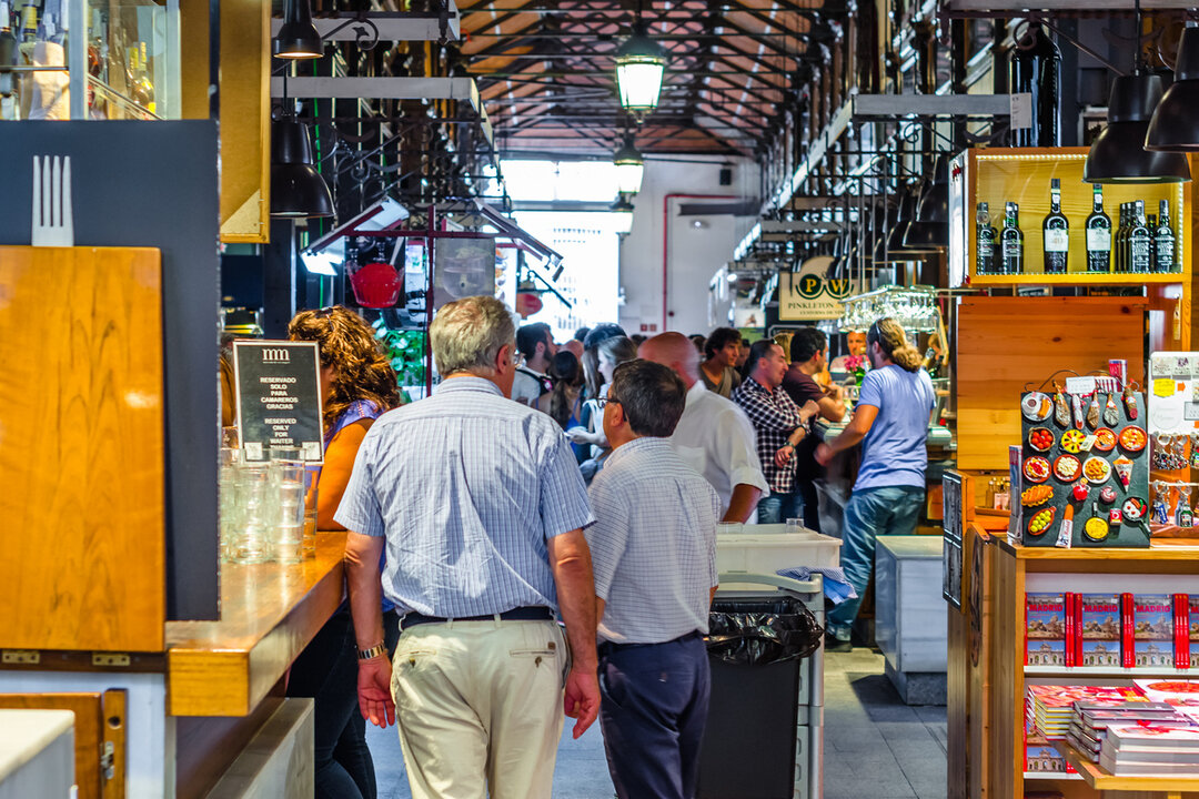 People visiting and enjoying drinks and tapas inside the historical Market of San Miguel in Madrid, Spain