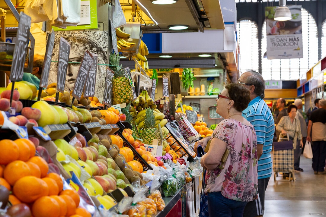 Locals buying fresh fruit at the Central Market in Malaga, Andalusia. Spain