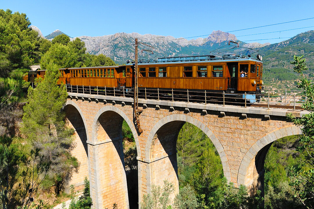 Historic wooden train crossing a bridge going from Palma de Majorca to Soller, Balearic Islands, Spain. 