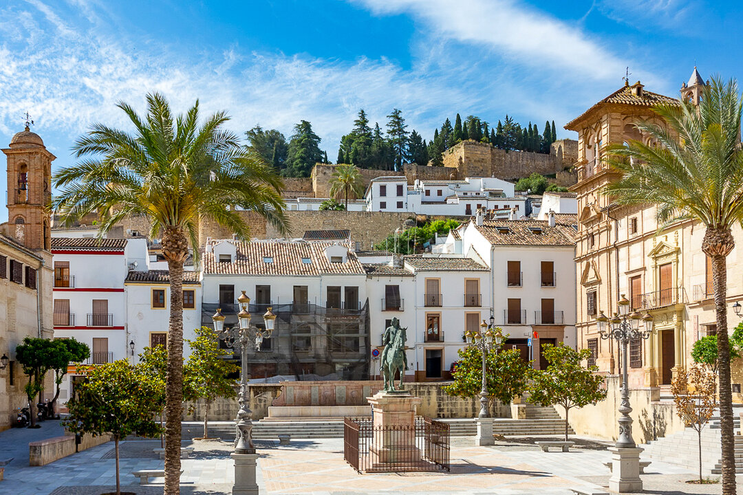 Charming Coso Viejo Square with whitewashed buildings and palm trees in Antequera, Province of Malaga, Andalusia, Spain.